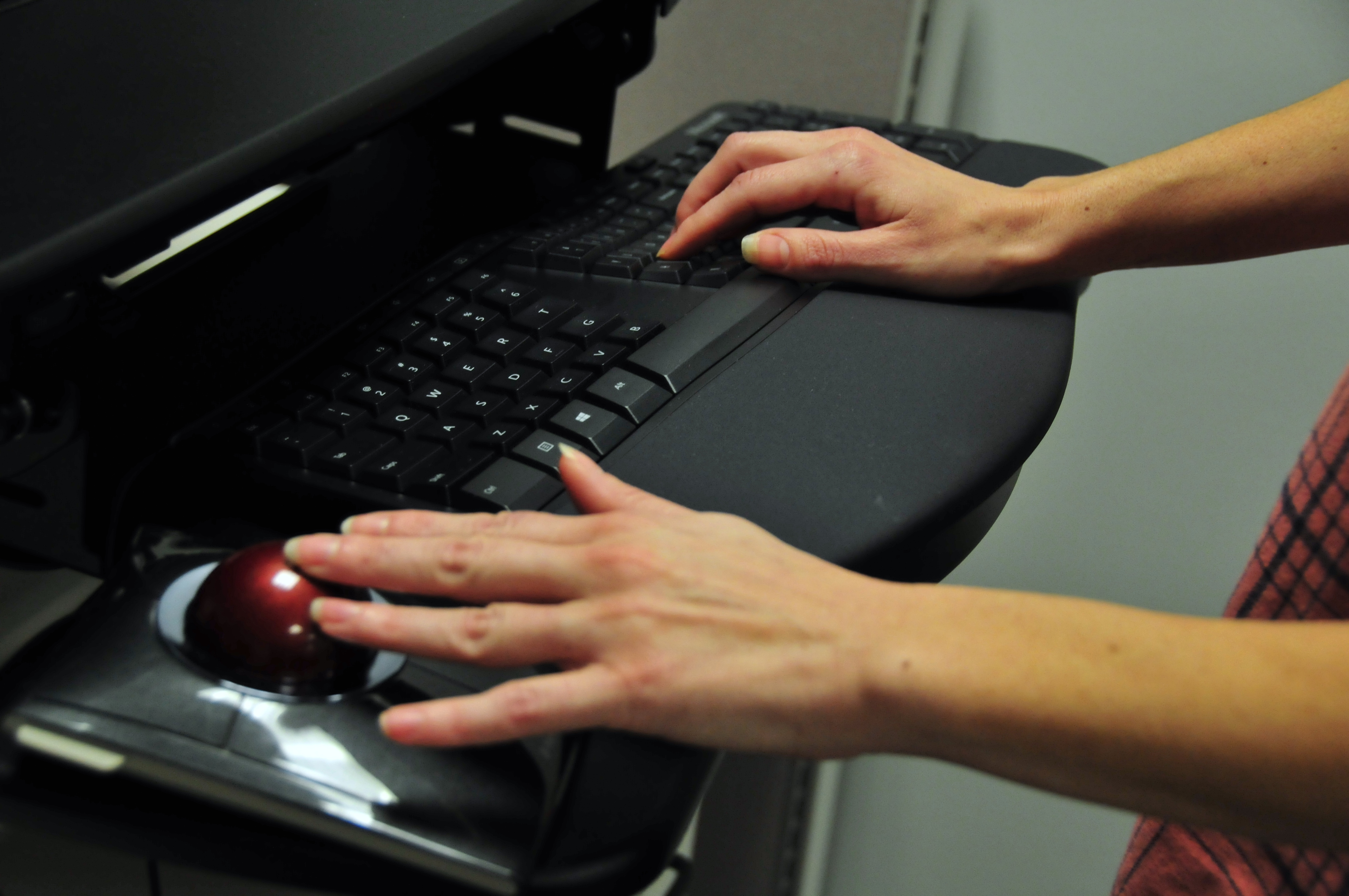 Person using a trackball mouse and ergonomic keyboard